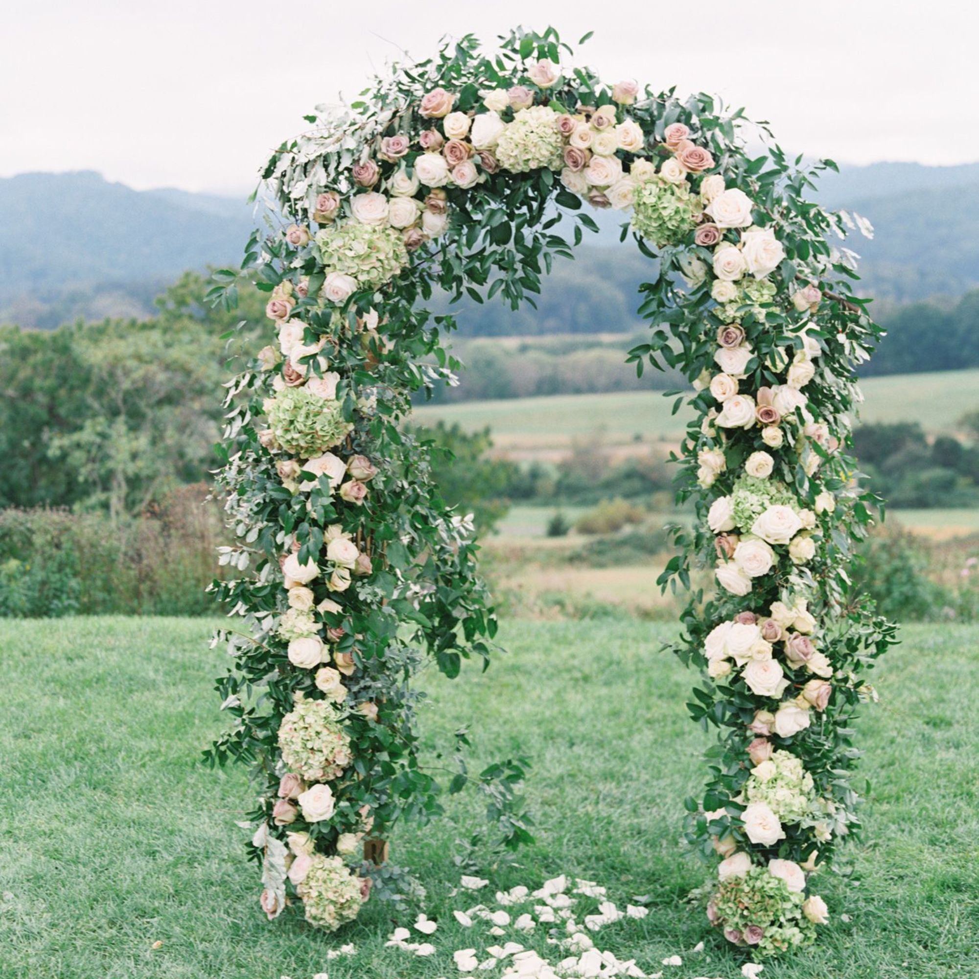 Dark Green Adjustable Garden Arch Trellis with Flowers On in a Garden Setting