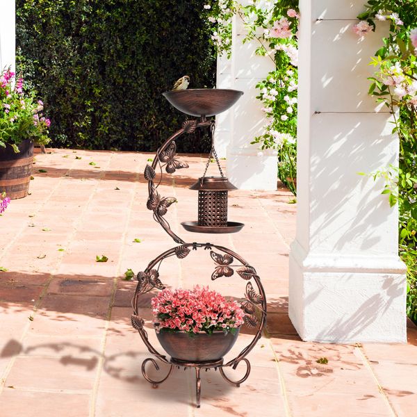 Solar Powered Bird Feeder, Bath and Decorative Planter Stand On A Patio With Pink Flowers