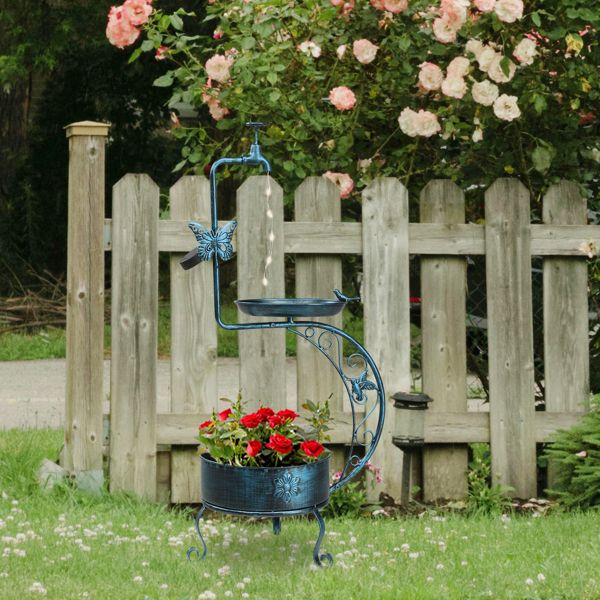 Vintage Metal Bird Bath with Solar Light and Planter In A Garden With Red Flowers