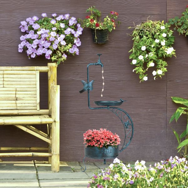 Vintage Metal Bird Bath with Solar Light and Planter In A Garden Beside A Bench